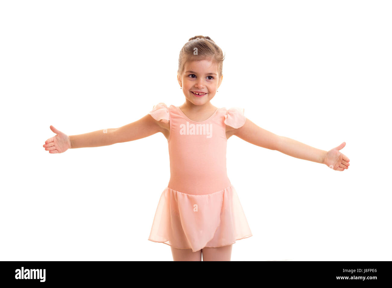 Optimistic little girl in pink dress dancing on white background in