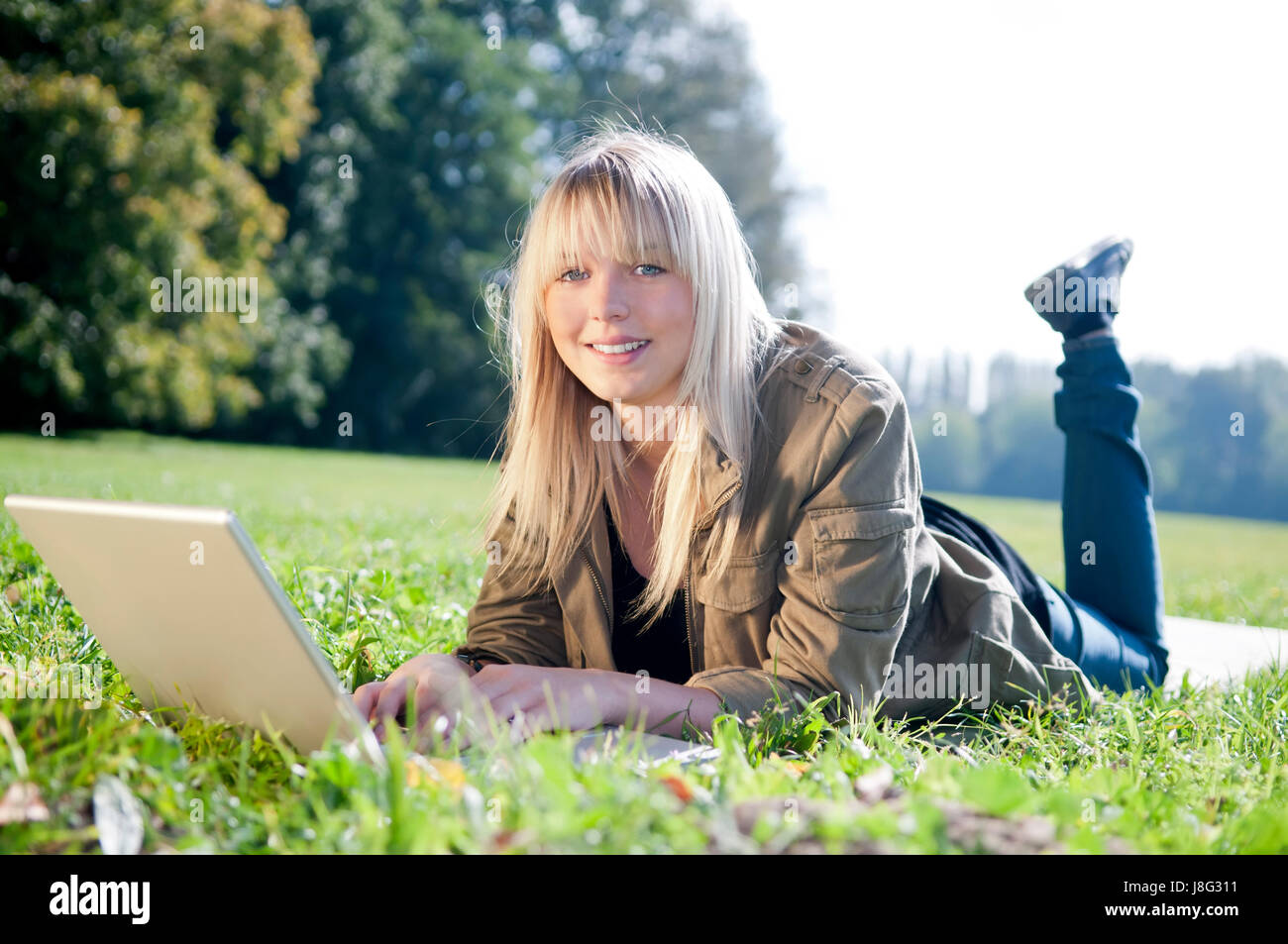 meadow young woman with laptop on a Stock Photo