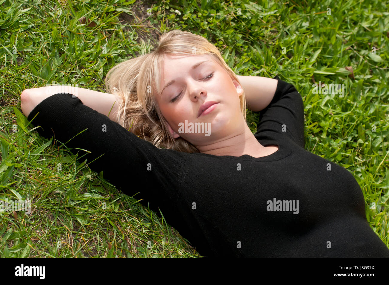young woman lying on a lawn Stock Photo