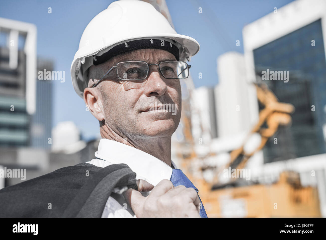 Senior elegant builder man in suit at construction site on sunny Stock ...
