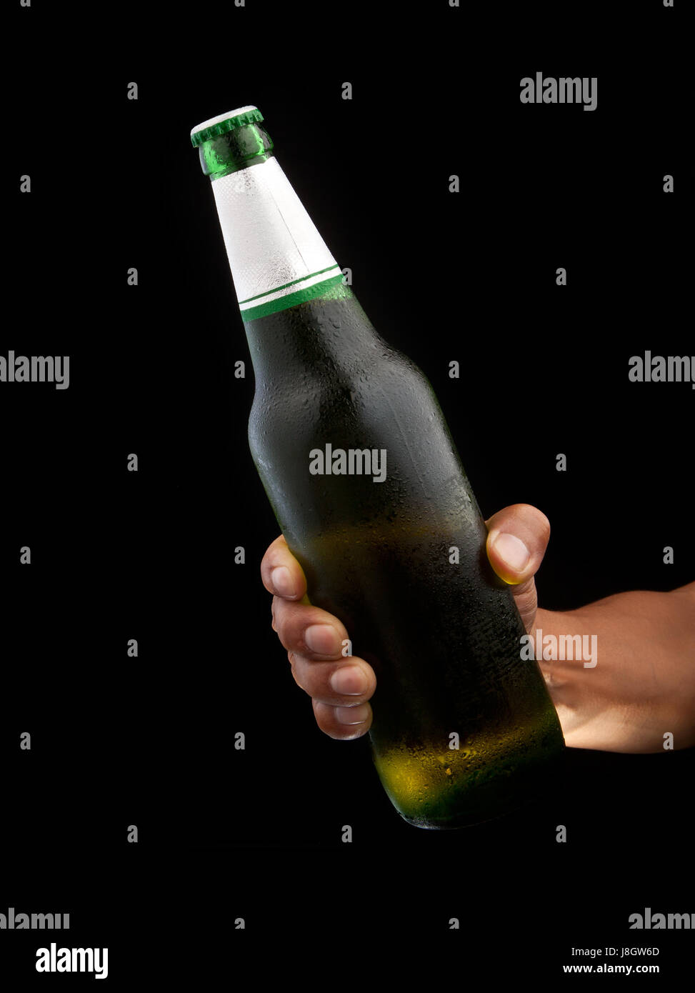 beer bottle in hand with black background Stock Photo Alamy