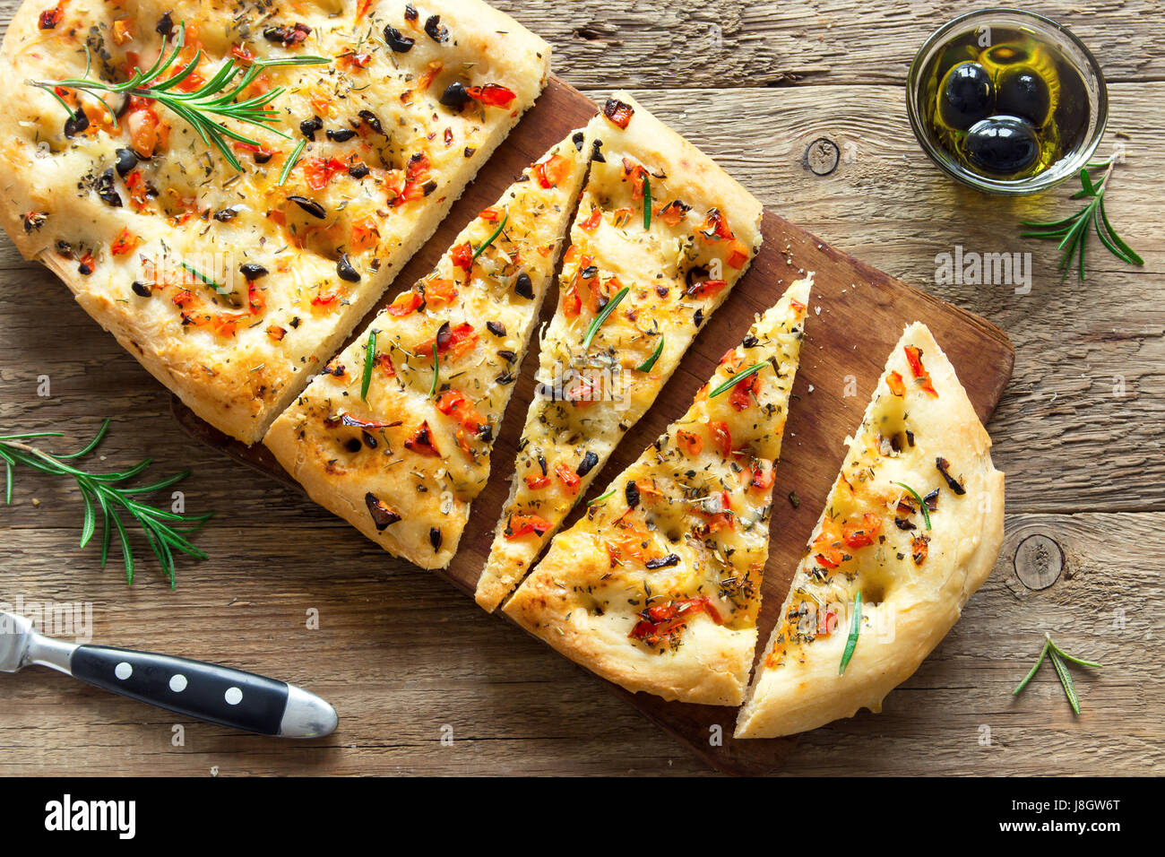 Traditional Italian Focaccia with tomatoes, black olives and rosemary