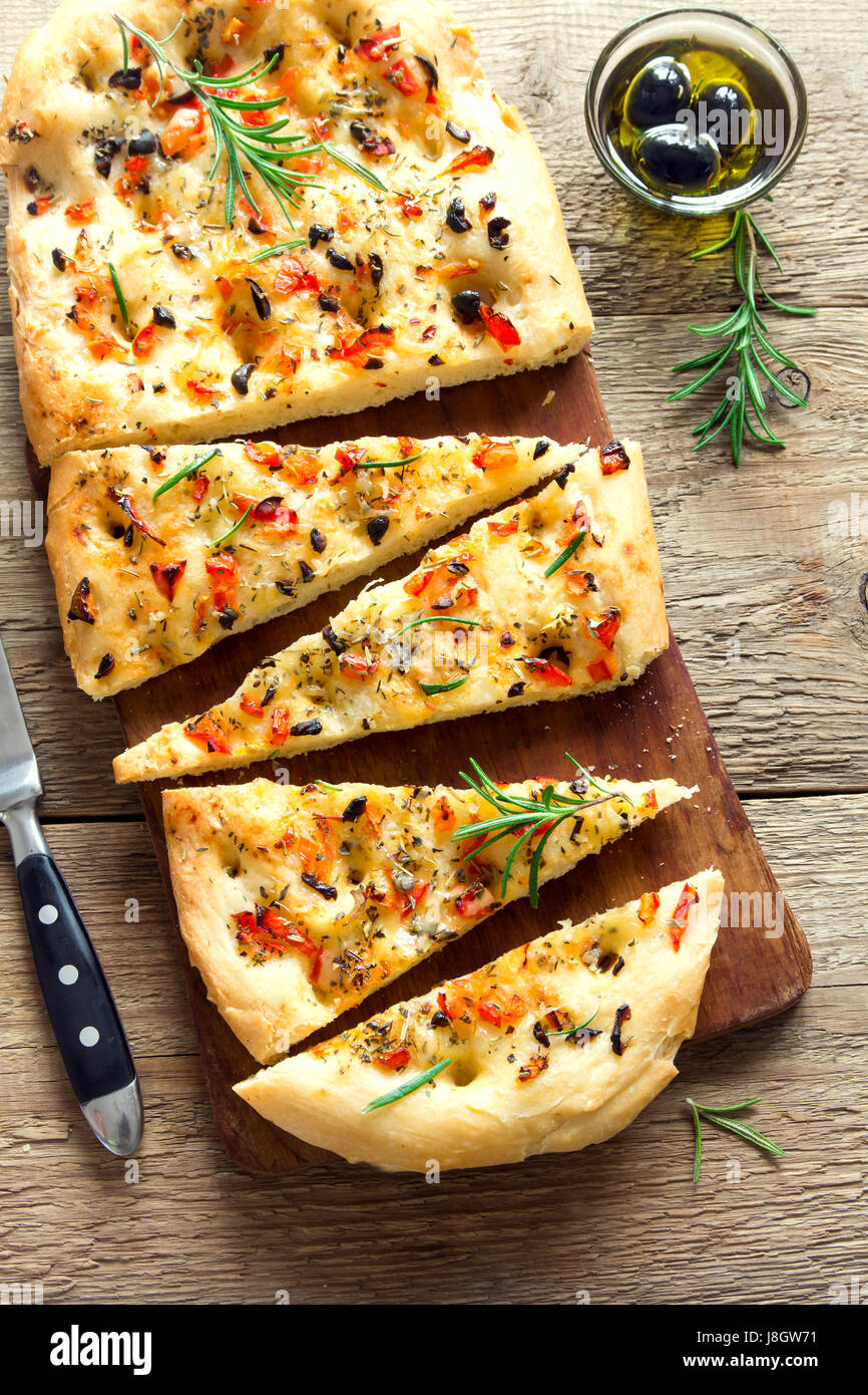 Traditional Italian Focaccia with tomatoes, black olives and rosemary