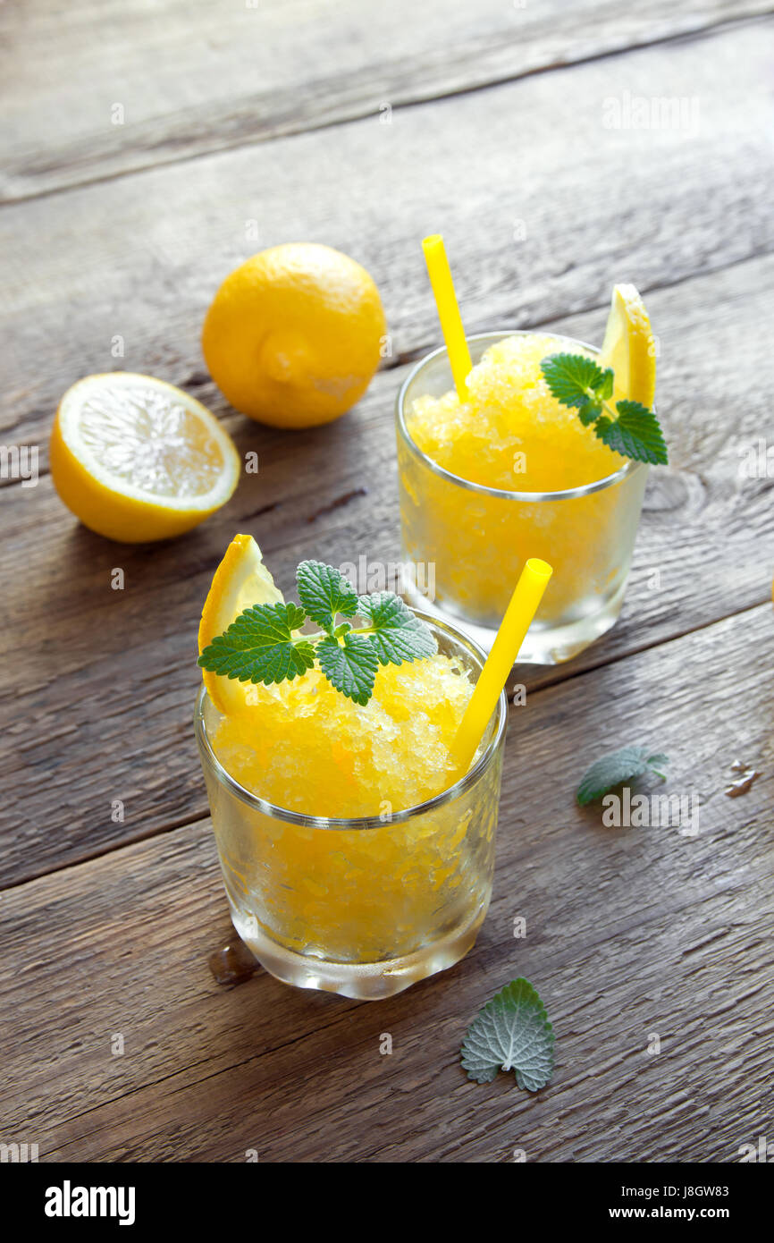 Lemon Frozen Granita Slush Drink in glasses on rustic wooden table