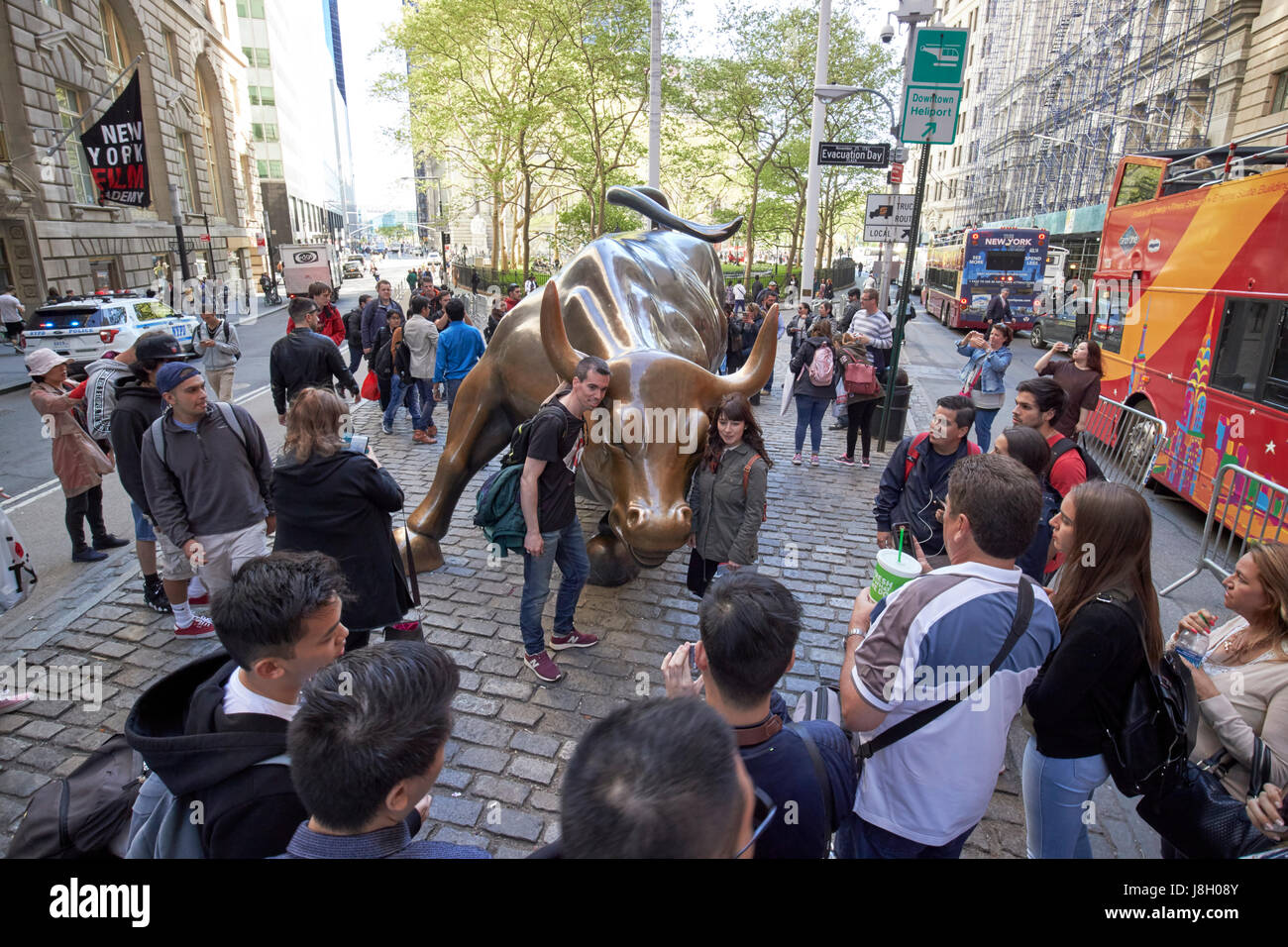 crowds at charging bull sculpture New York City public art bowling green broadway USA Stock Photo