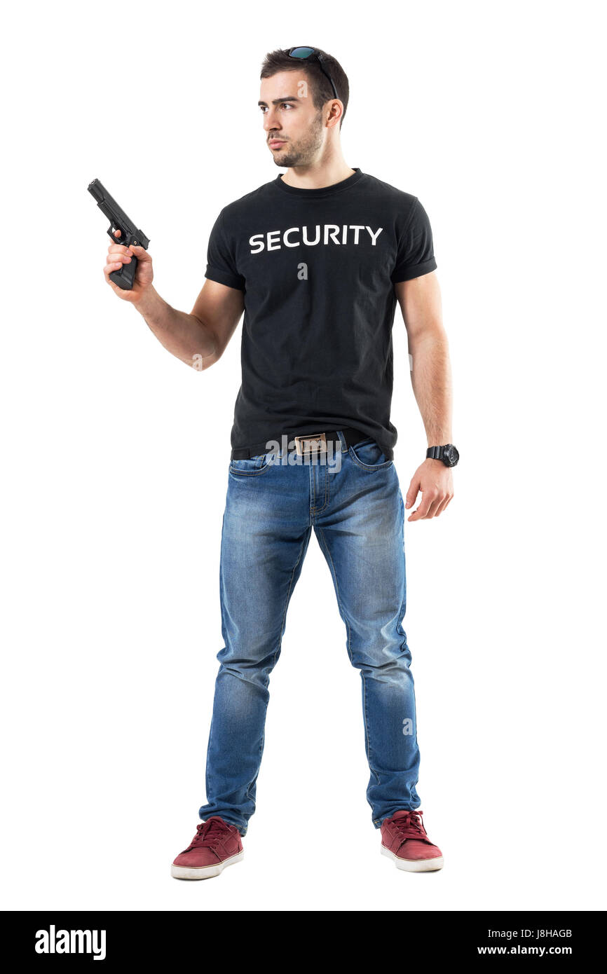 Alerted cautious plain clothes policeman holding gun looking away. Full body length portrait isolated on white studio background. Stock Photo