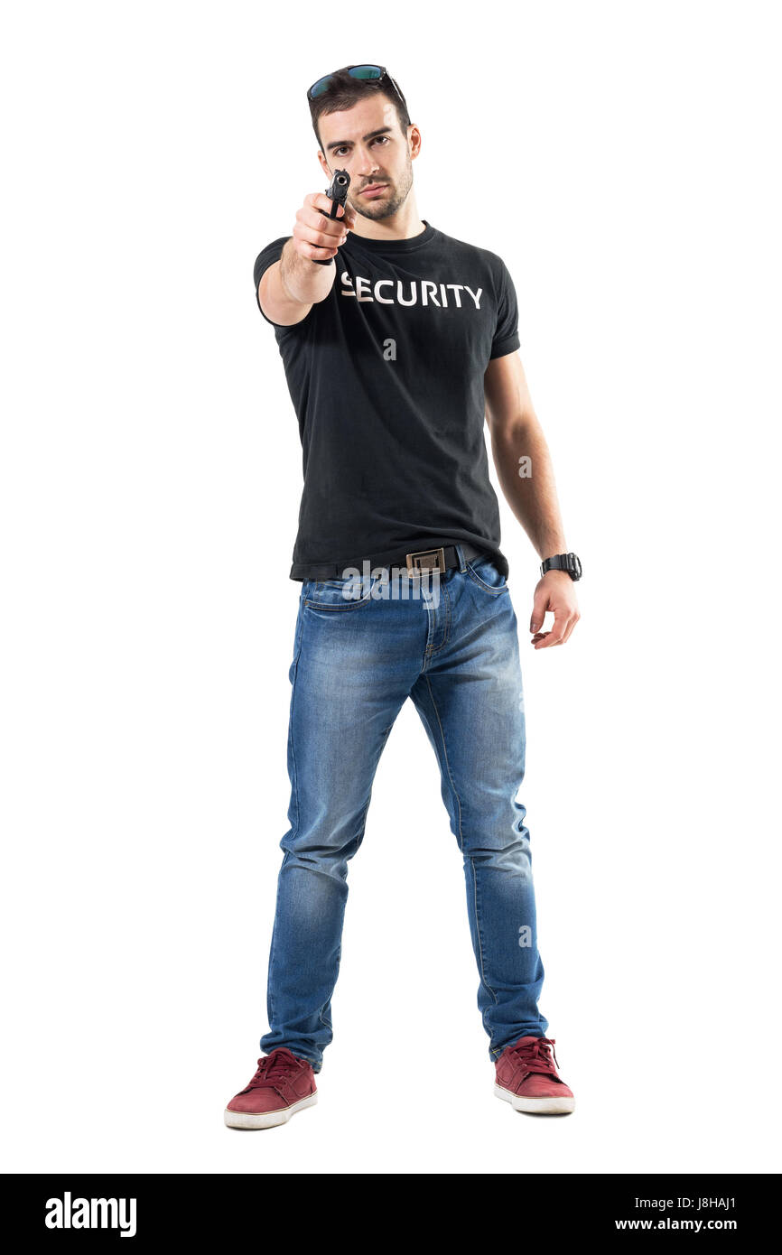Undercover police man holding gun in one hand pointing at you. Full body length portrait isolated on white studio background. Stock Photo