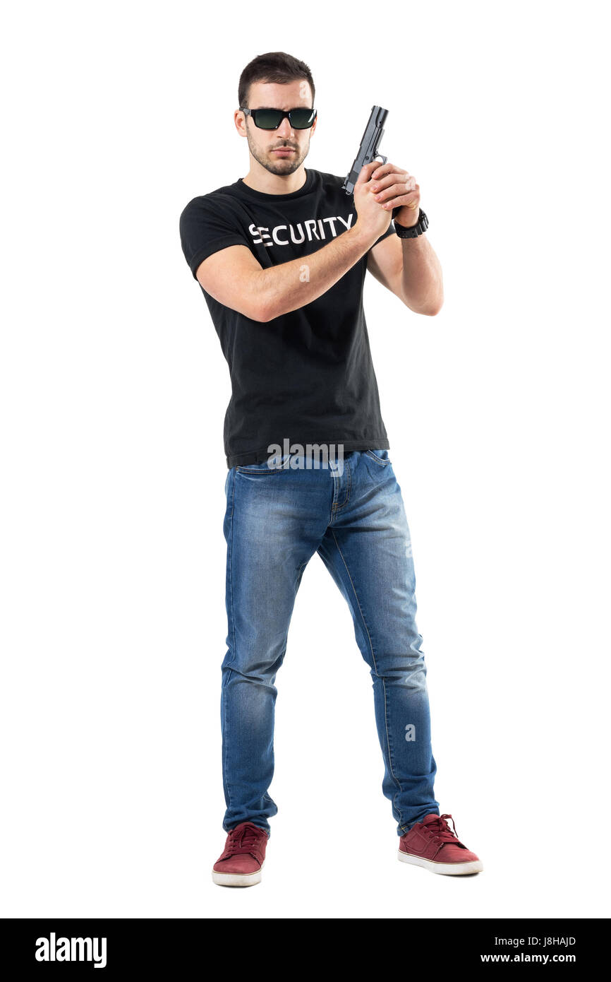 Ready alerted undercover officer holding gun in both hands looking at camera. Full body length portrait isolated on white studio background. Stock Photo