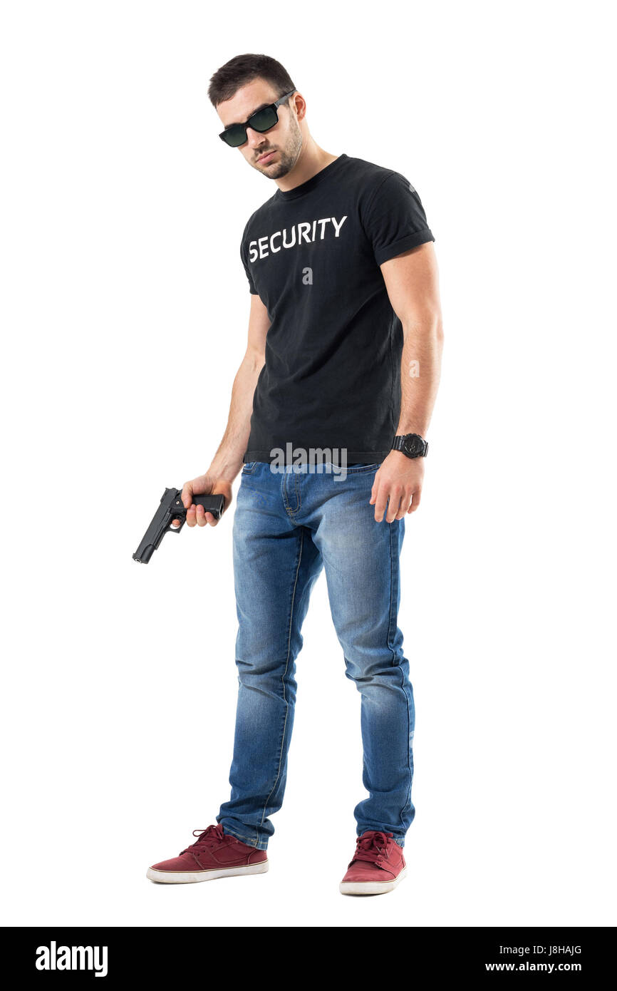 Tough confident plain clothes officer with sunglasses holding gun looking at camera. Full body length portrait isolated on white studio background. Stock Photo