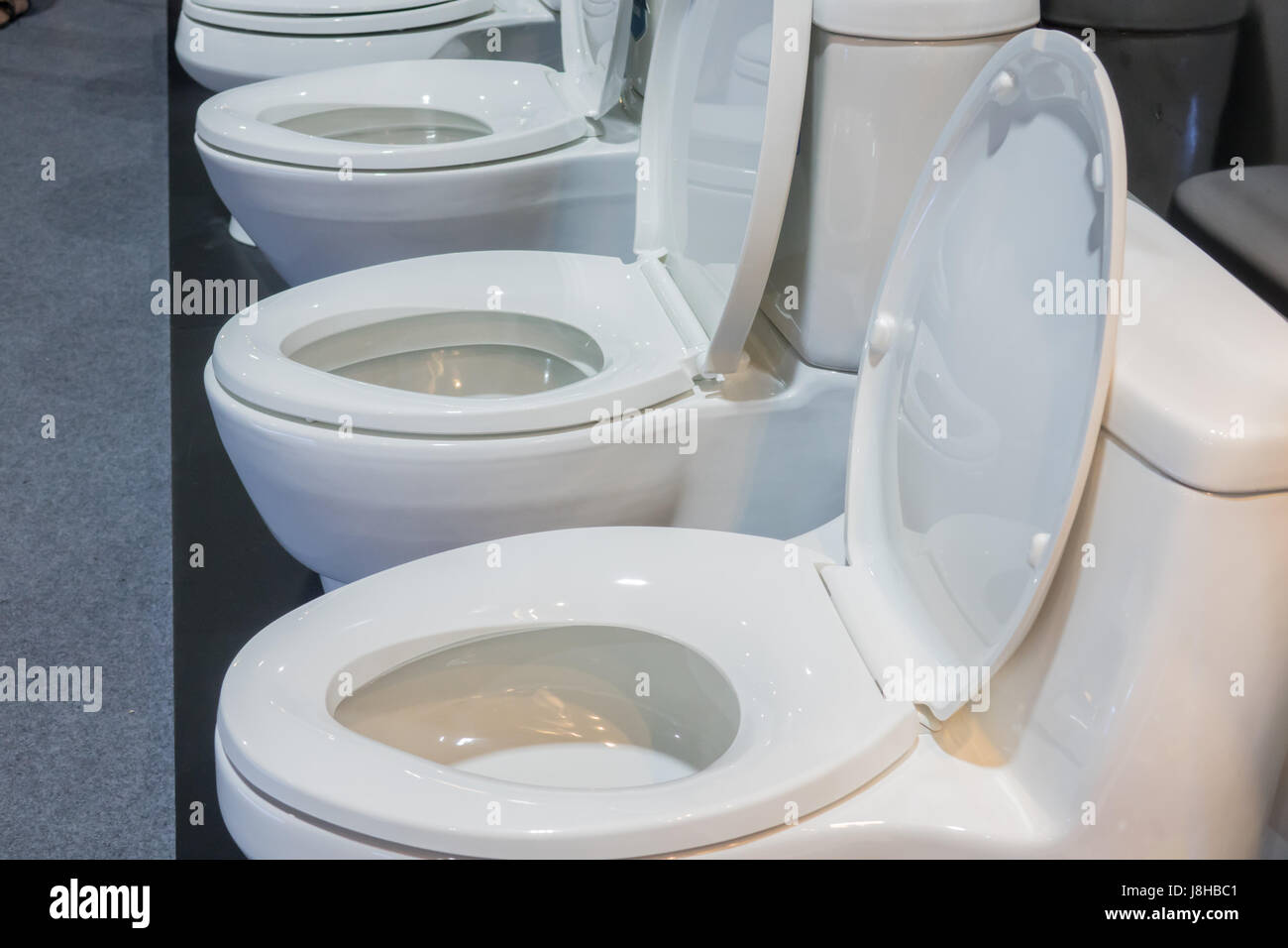 Picture of a bathroom flush in a showroom,Modern Toilet bowl in a men bathroom,white ceramic flush toilet Stock Photo