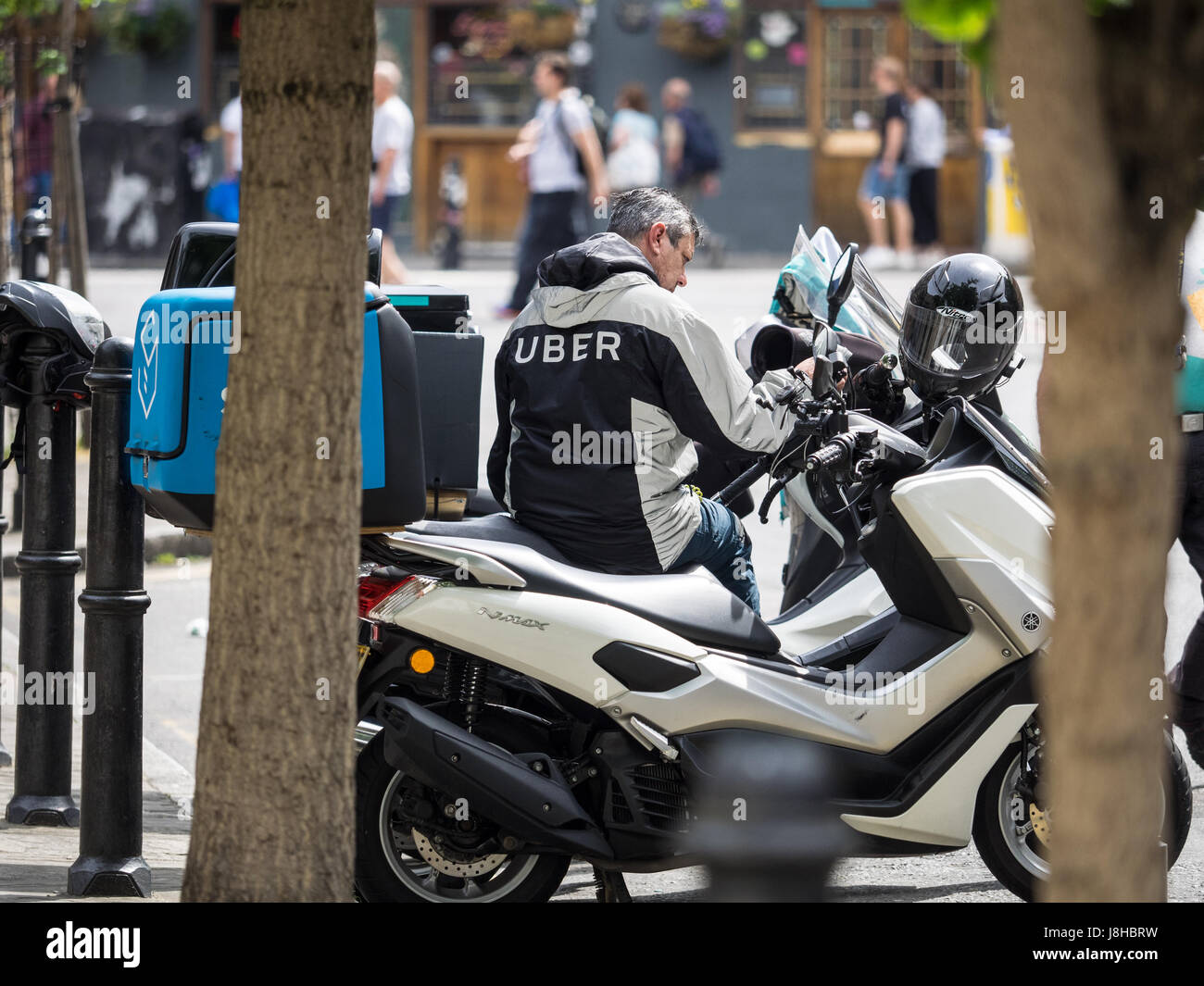 An Uber Eats food delivery courier waits for work Stock Photo Alamy