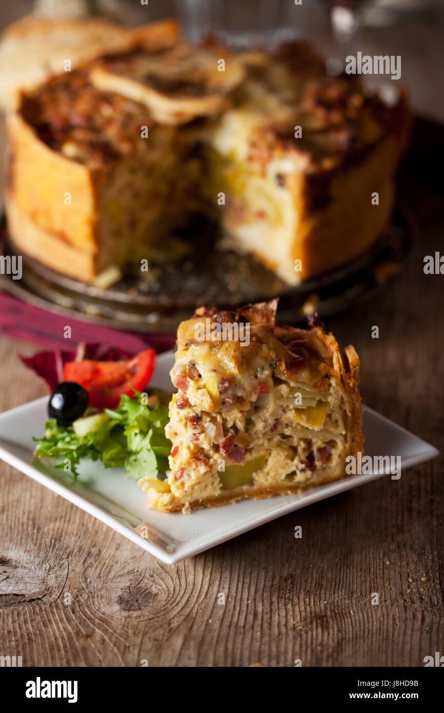 piece of quiche lorraine with salad and wine Stock Photo