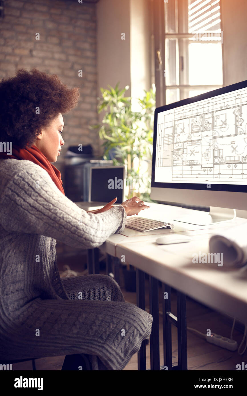 African female works on computer in architect project office Stock Photo