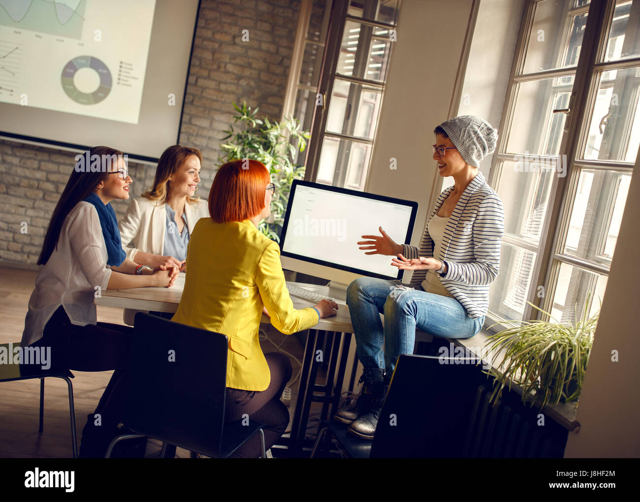 Women at workplace presents ideas one to another for new business Stock Photo