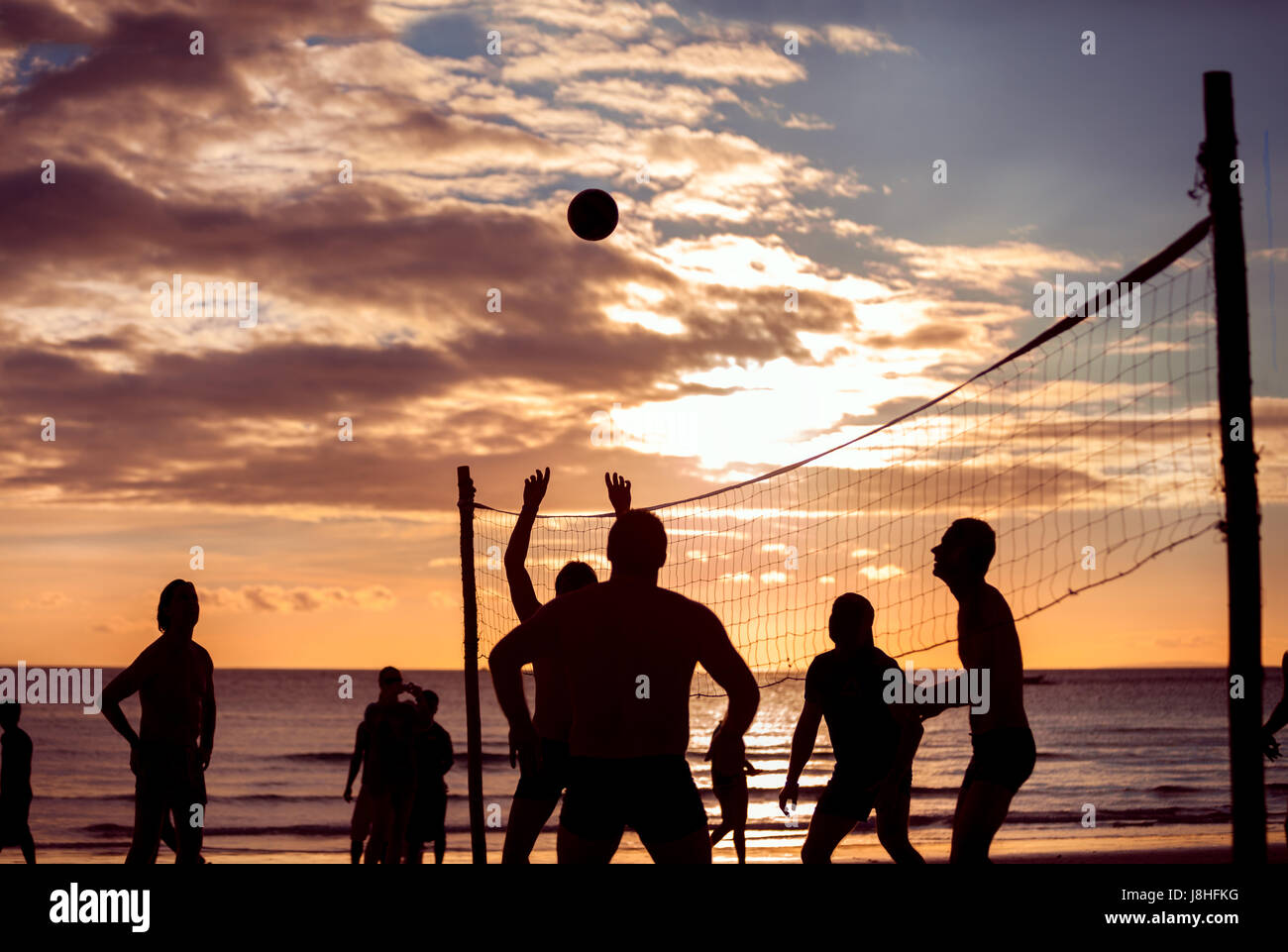 Silhouette play beach volleyball, sunset time Stock Photo Alamy