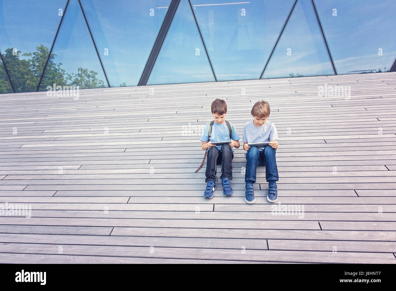 Children playing with tablet computer outdoor. People education learning technology leisure concept Stock Photo