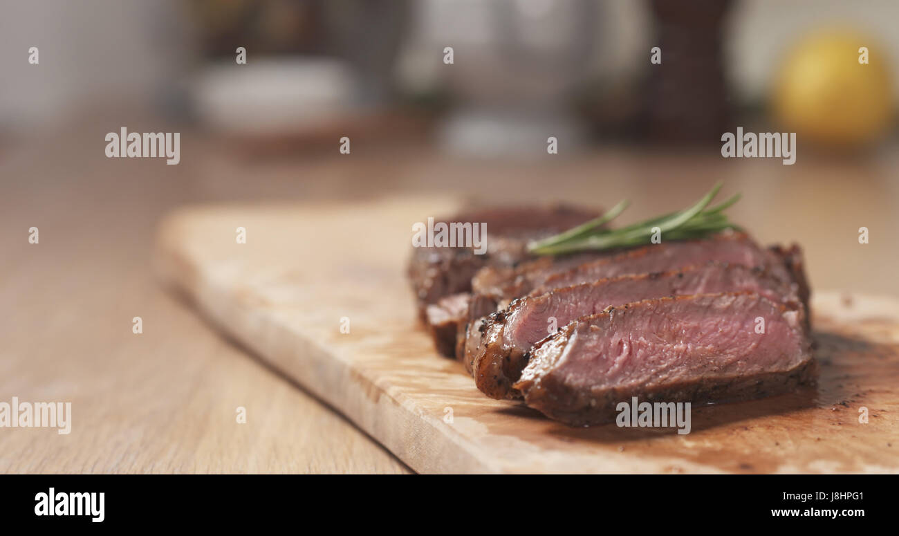 sliced medium rib eye steak with rosemary branch Stock Photo - Alamy