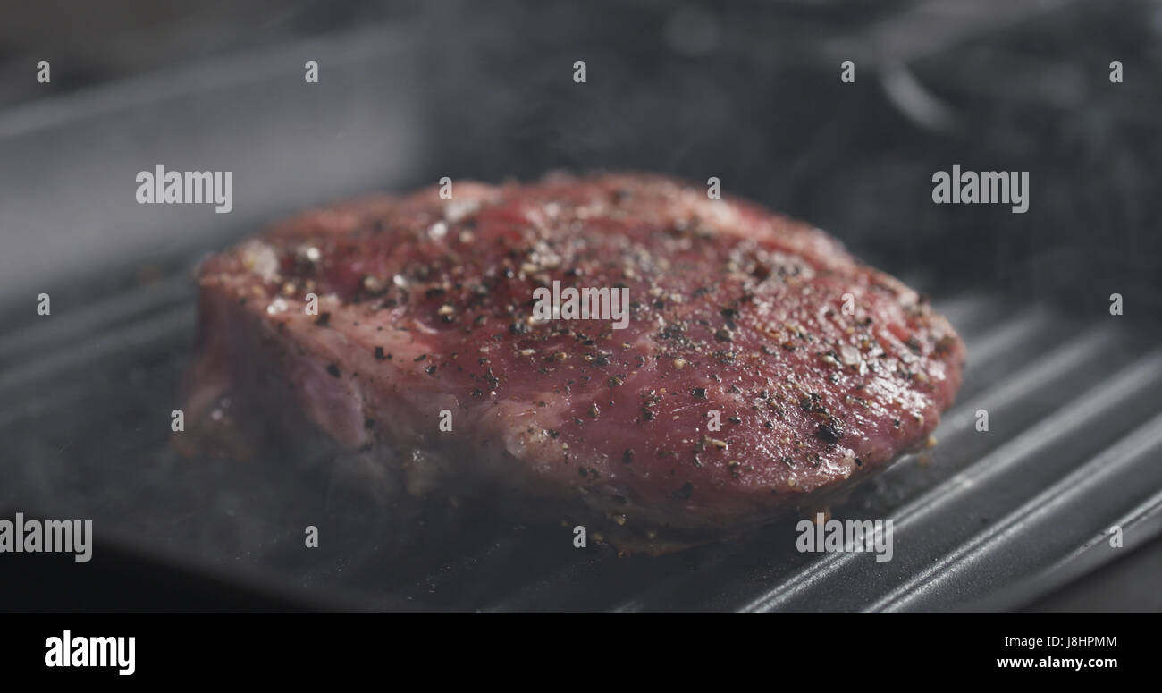 cooking rib eye steak on grill pan Stock Photo Alamy