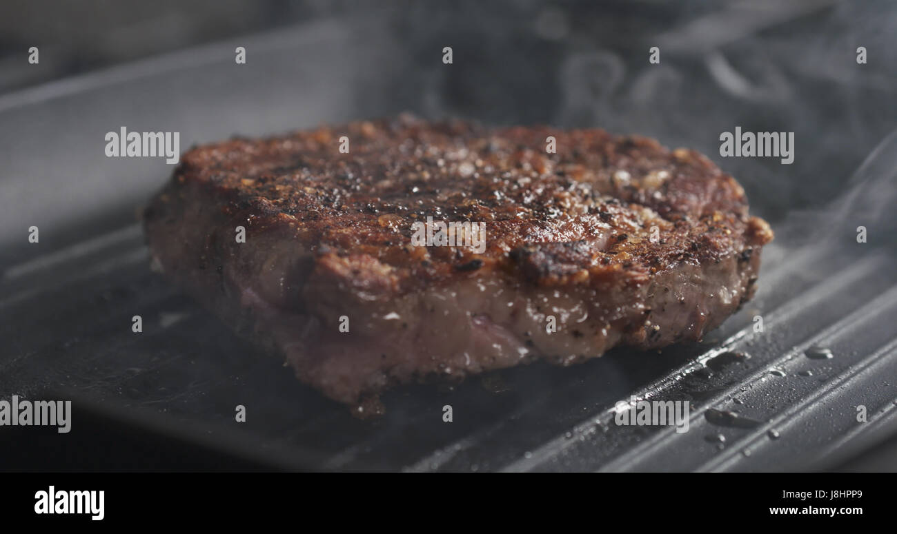 cooking rib eye steak on grill pan Stock Photo Alamy