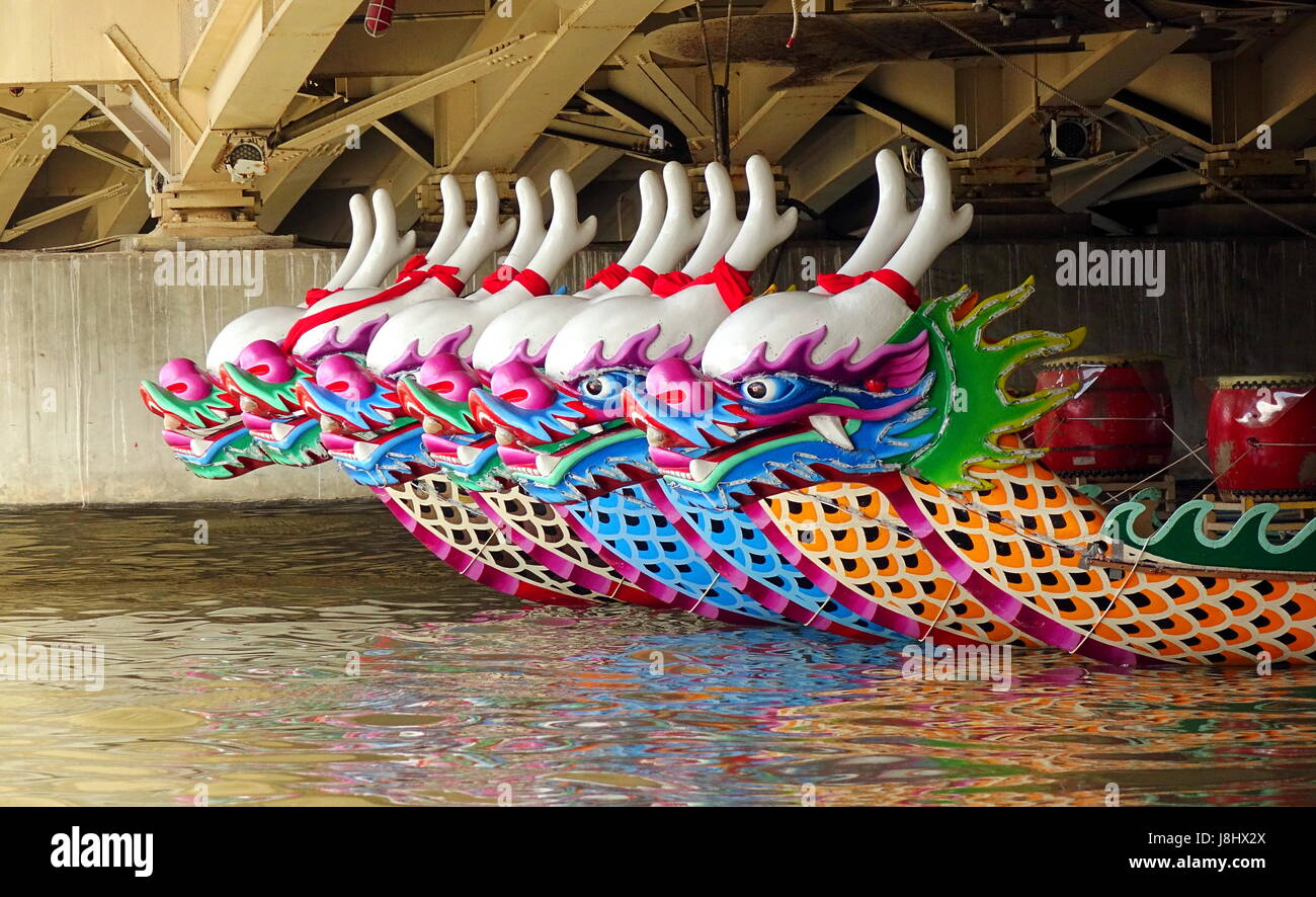 KAOHSIUNG, TAIWAN -- MAY 21, 2017: Traditional dragon boats are anchored under a bridge on the Love River in preparation for the upcoming Dragon Boat  Stock Photo