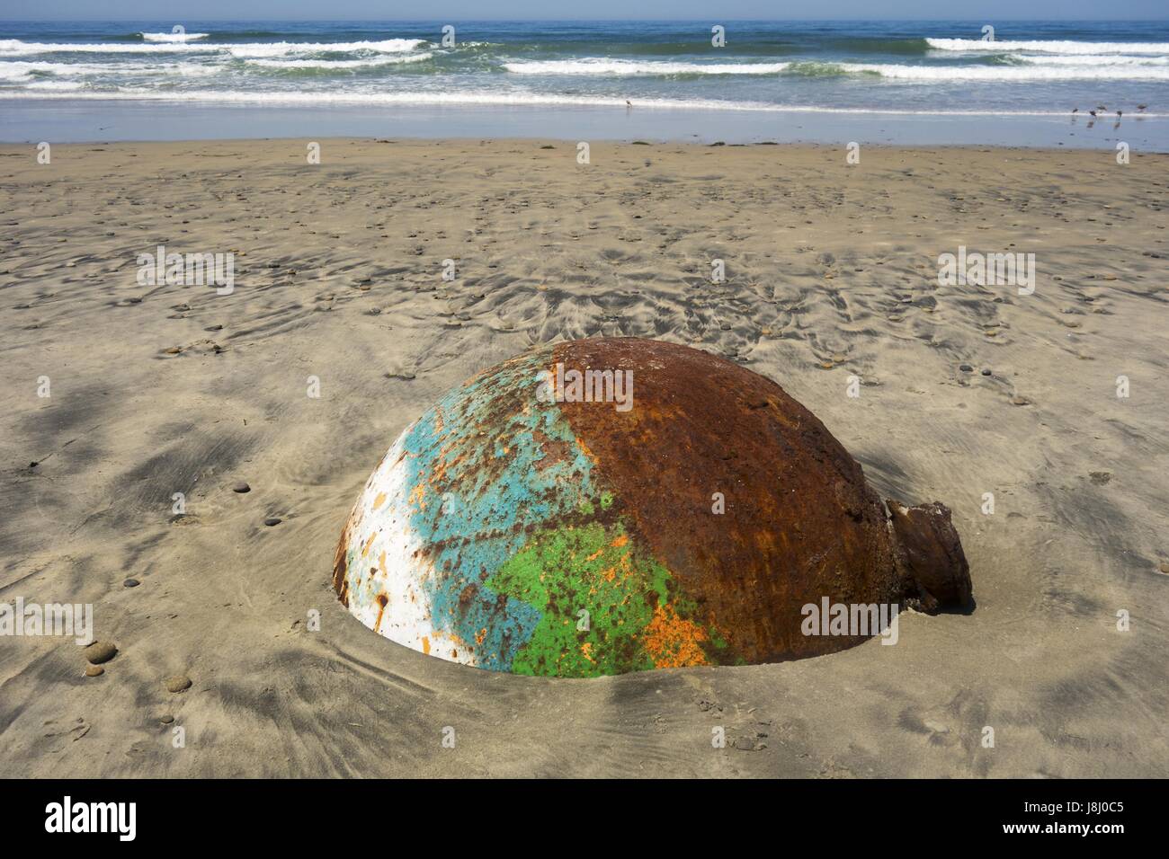 Old Rusted Sea Buoy Washed out by Pacific Ocean High Tide on Torrey Pines State Black Beach Sand north of La Jolla Shores in San Diego California Stock Photo