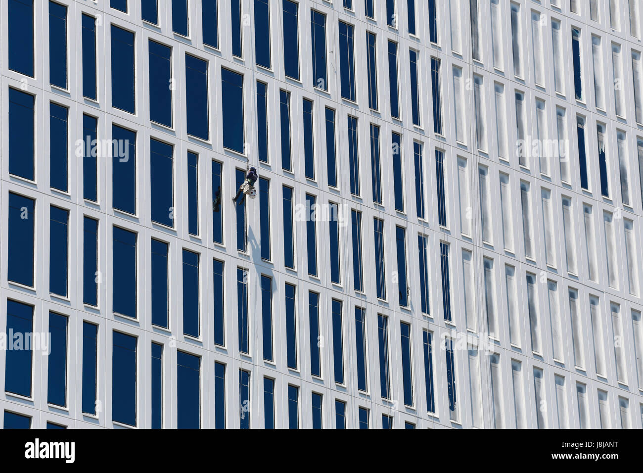 Glass wipers men are work cleaning on the tall buildings Stock Photo