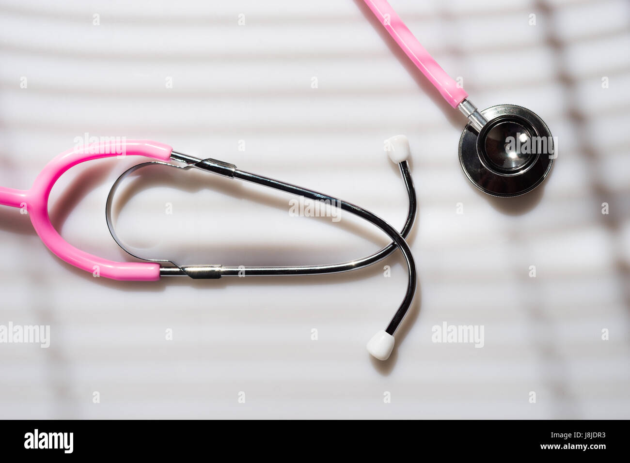 Window light washed over a Stethoscope in the doctors office Stock Photo