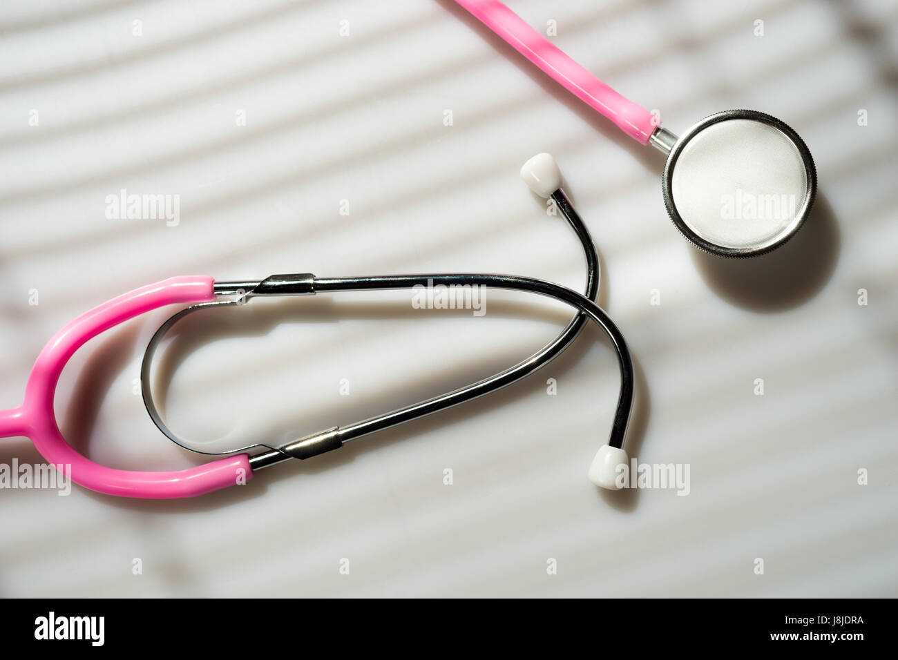 Window light washed over a Stethoscope in the doctors office Stock Photo