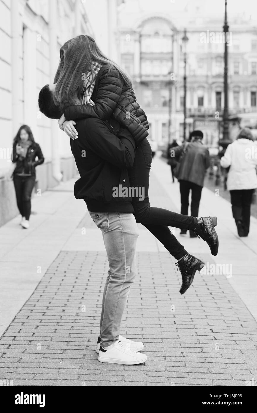 Young beautiful couple in love kissing and hugging at city street on
