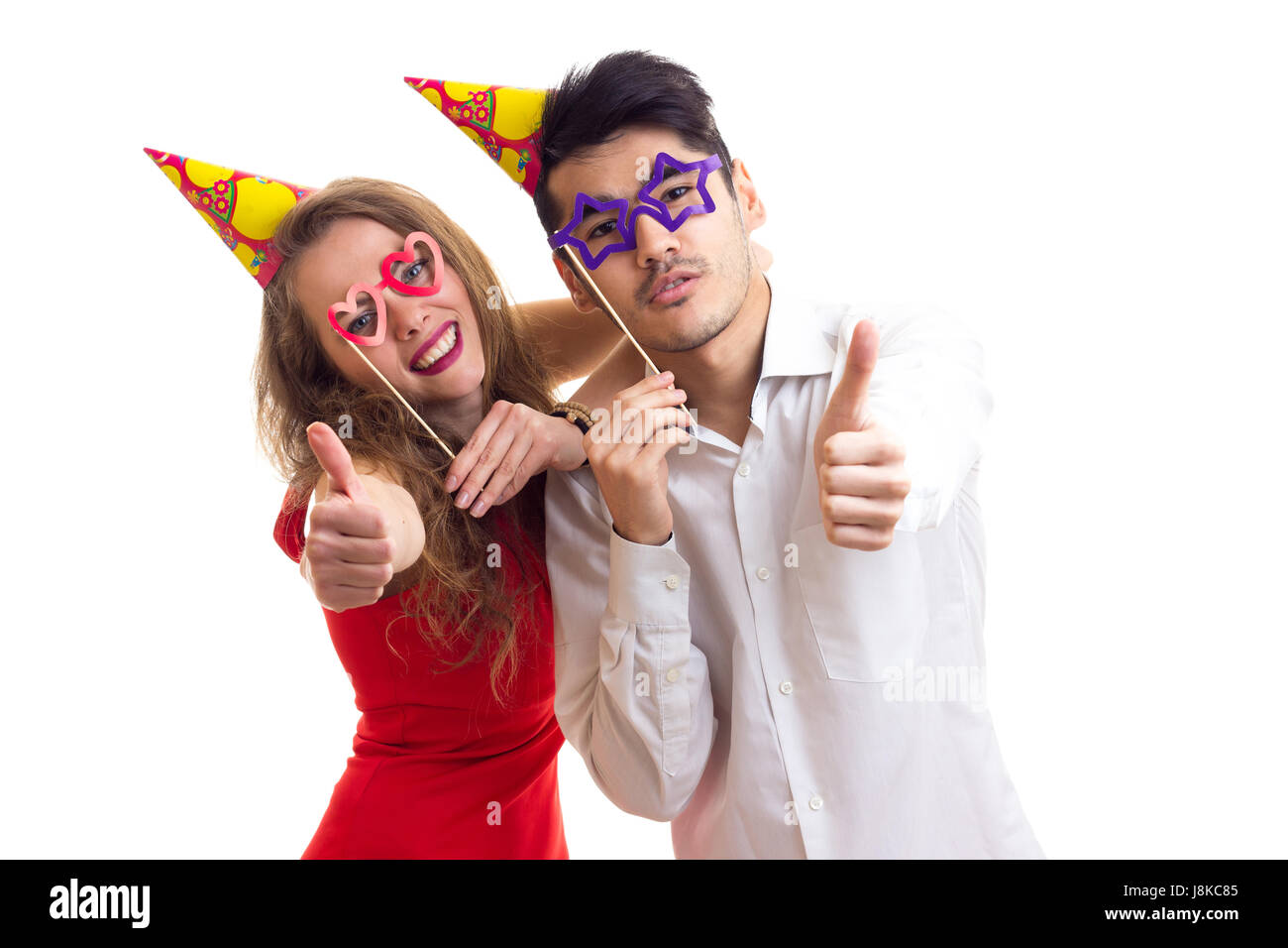 Young couple with card sticks and celebrating hats Stock Photo