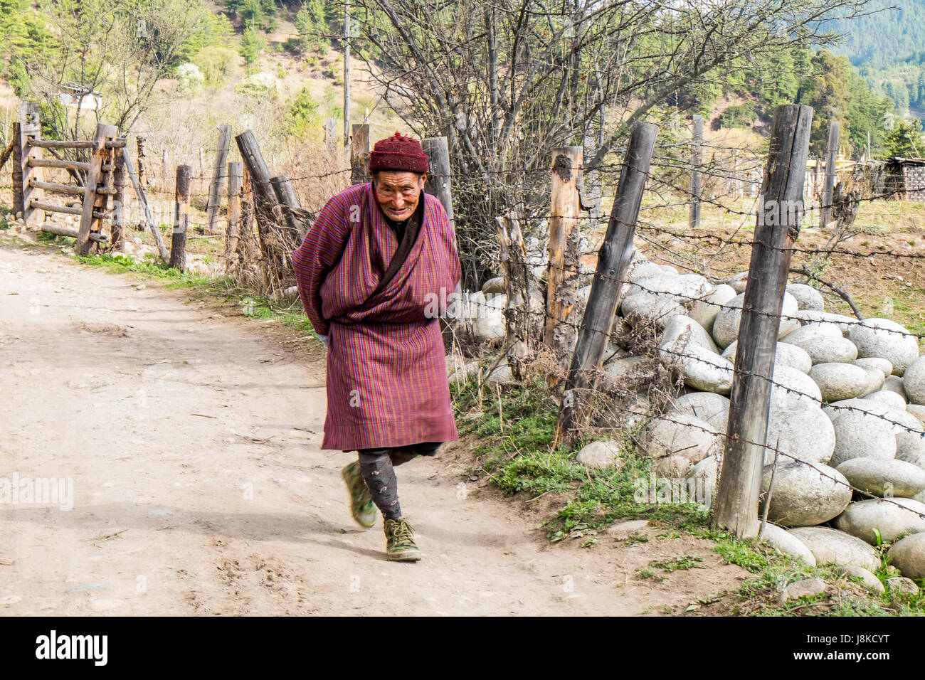 Man walking on dirt road along a livestock farm in a remote village in Central Bhutan. Stock Photo