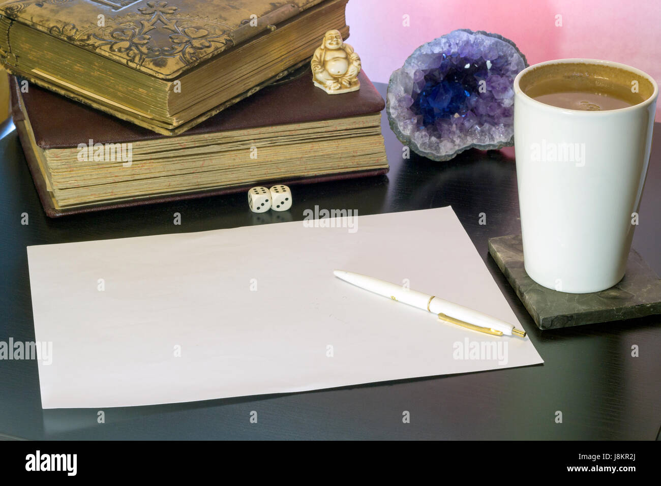 Composition from a white sheet, a cup of coffee, old albums, an amethyst drusa vintage figurines and a pen Stock Photo