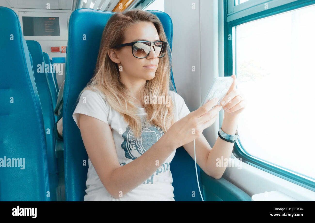 Woman on train with phone, student or business woman Stock Photo