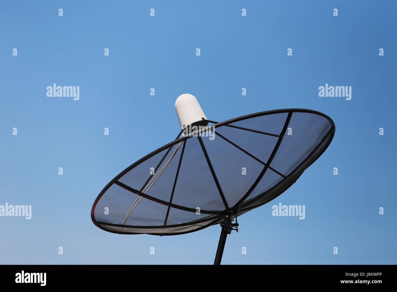 Black Satellite dish on blue sky background. Stock Photo