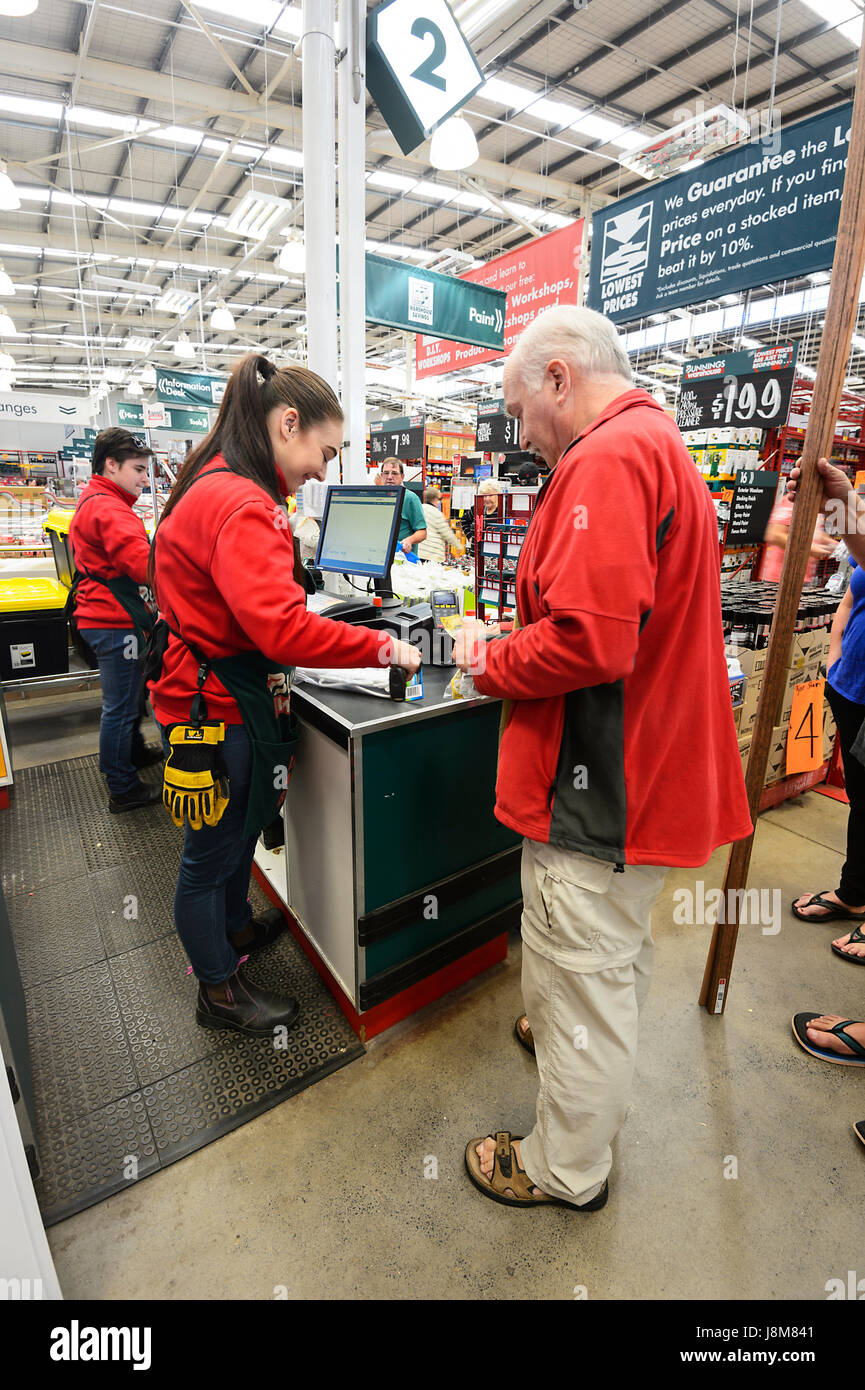 Mature man paying at the checkout at Bunnings Warehouse, a home improvements store, Shellharbour, New South Wales, NSW, Australia Stock Photo