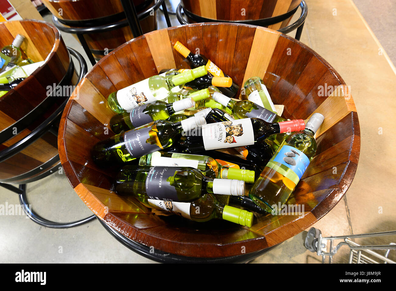Bottles of wine on display in a half barrel at Dan Murphy's Liquor Store, Shellharbour, New South Wales, NSW, Australia Stock Photo