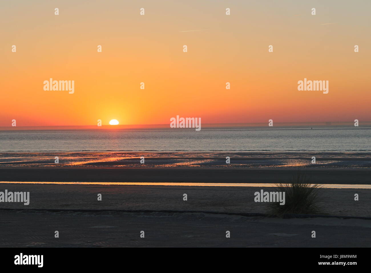 A sunset plunging into the cloudless North Sea Stock Photo