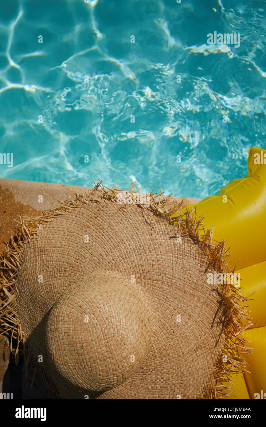 hat on a yellow air mattress in swimming pool. Tropical summer concept. Stock Photo