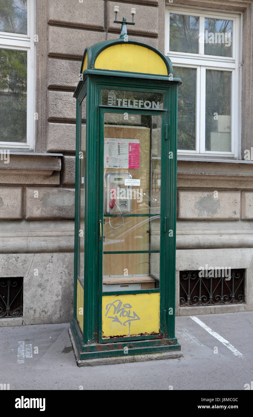 A traditional green and yellow public telephone booth/box in Budapest, Hungary. Stock Photo