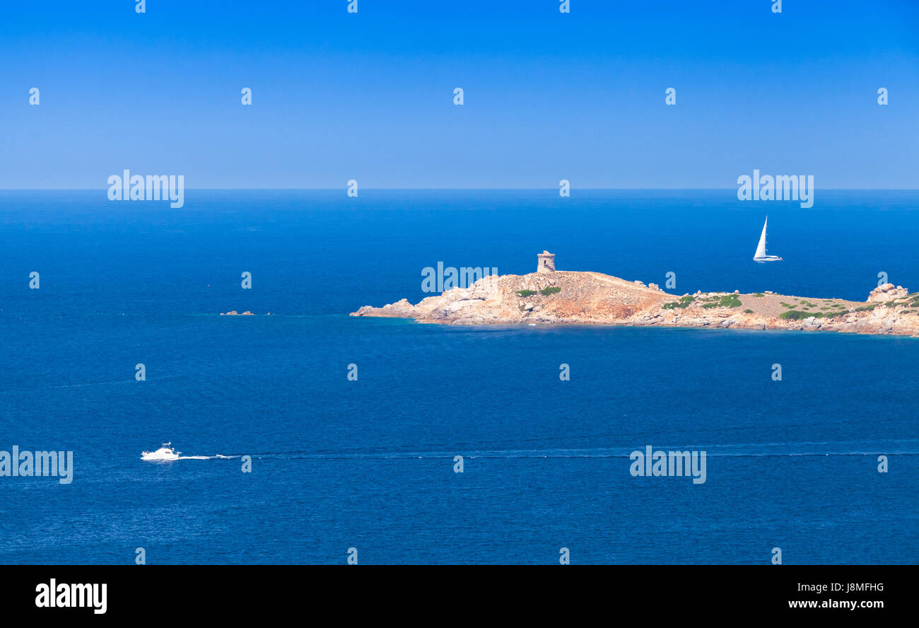 Sailing yacht and pleasure motorboat go near rocky coast of Corsica island. Summer panoramic seascape Stock Photo