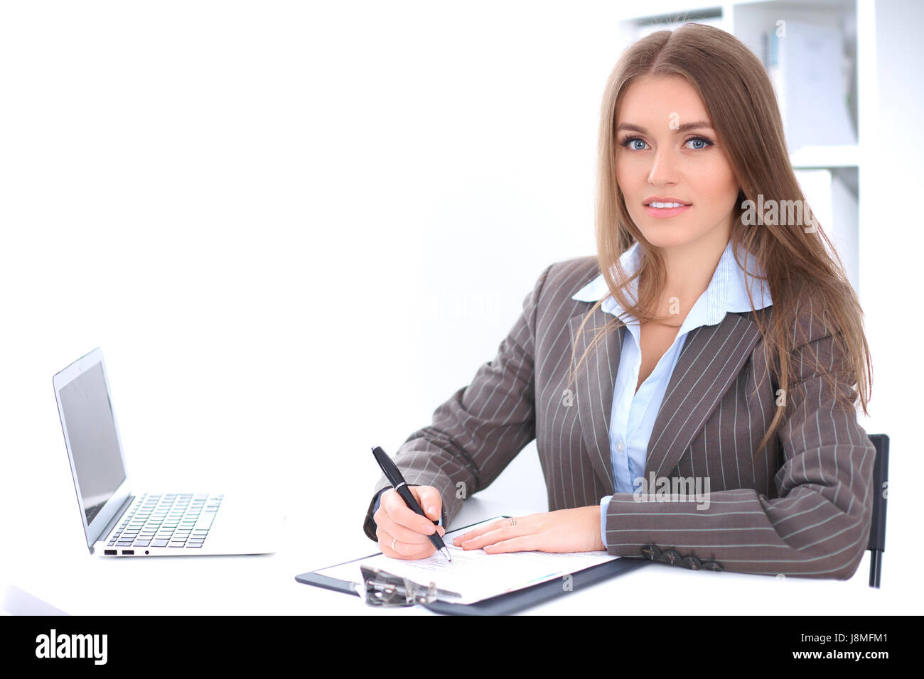 Young business woman sitting at the desk on office background Stock ...