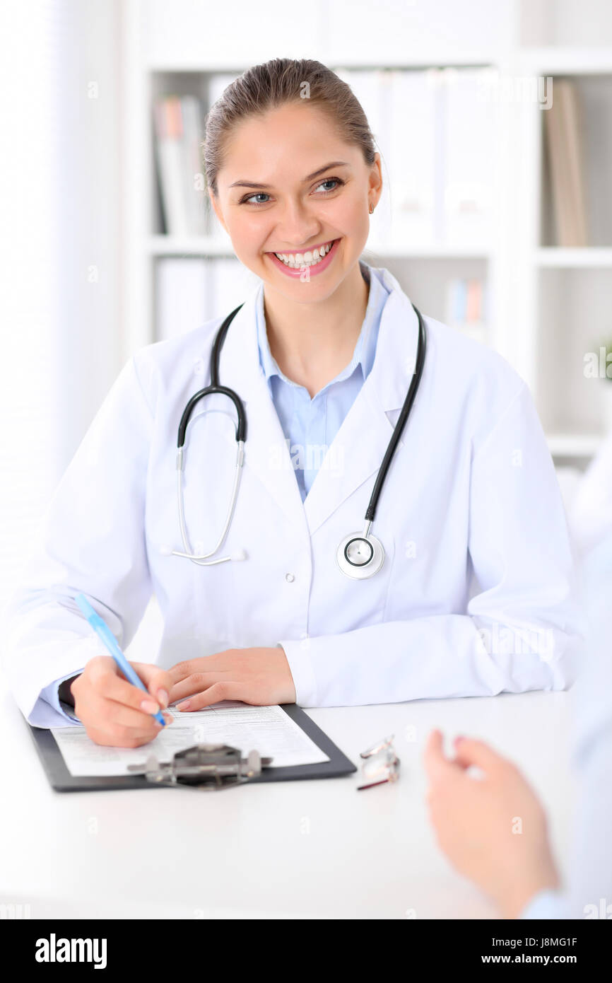 Friendly smiling doctor and patient sitting at the table. Very good