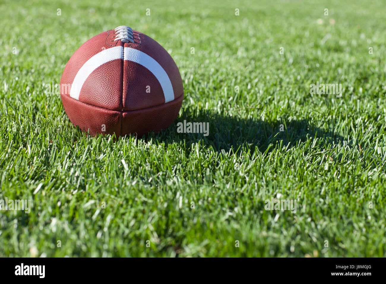 Selective focus, low angle view of a college style football on a grass field Stock Photo