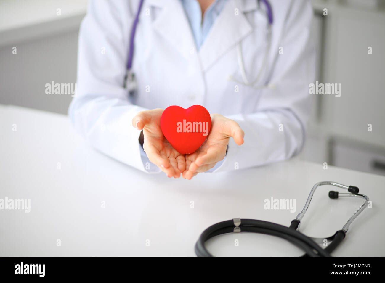 Female doctor with stethoscope holding heart Stock Photo - Alamy