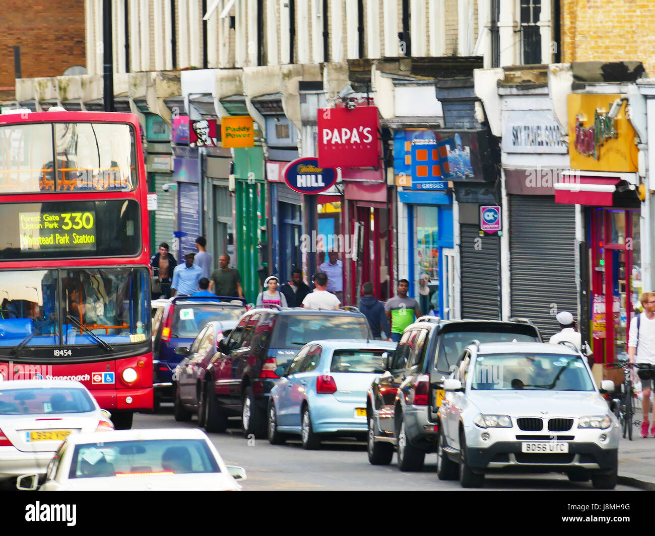 Shops, bus and traffic in a busy Woodgrange Road, Forest Gate, London E7 Stock Photo