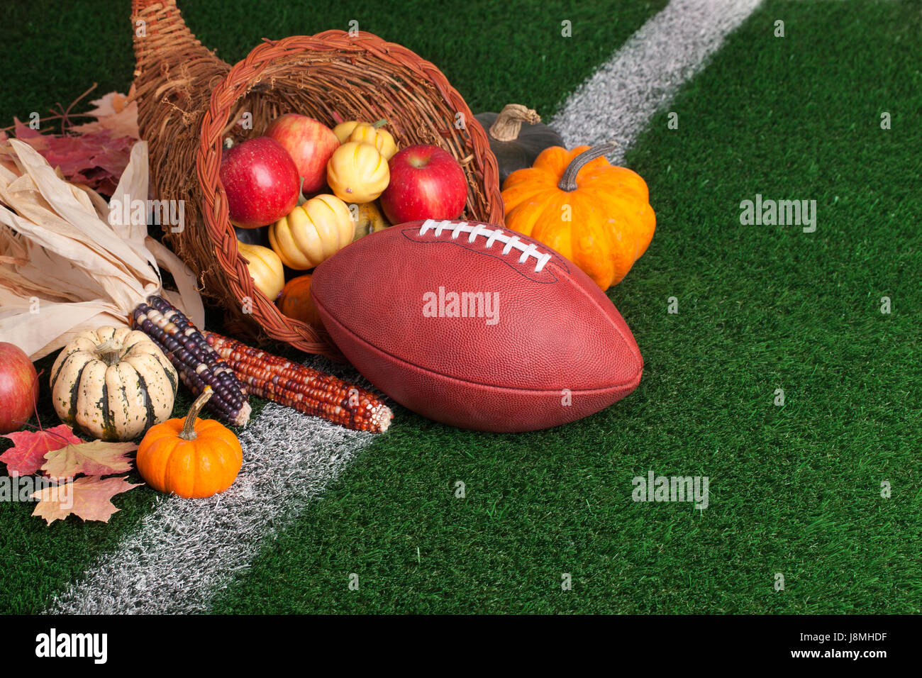 Football in a cornucopia with autumn harvest produce Stock Photo