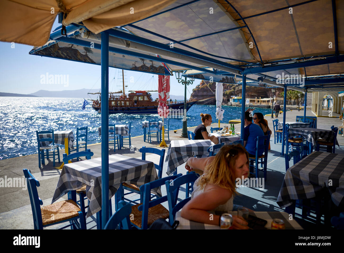 Volcanic Greek island Santorini one of the Cyclades islands in the Aegean Sea. Fira the islands capital old town harbour restaurant. Stock Photo
