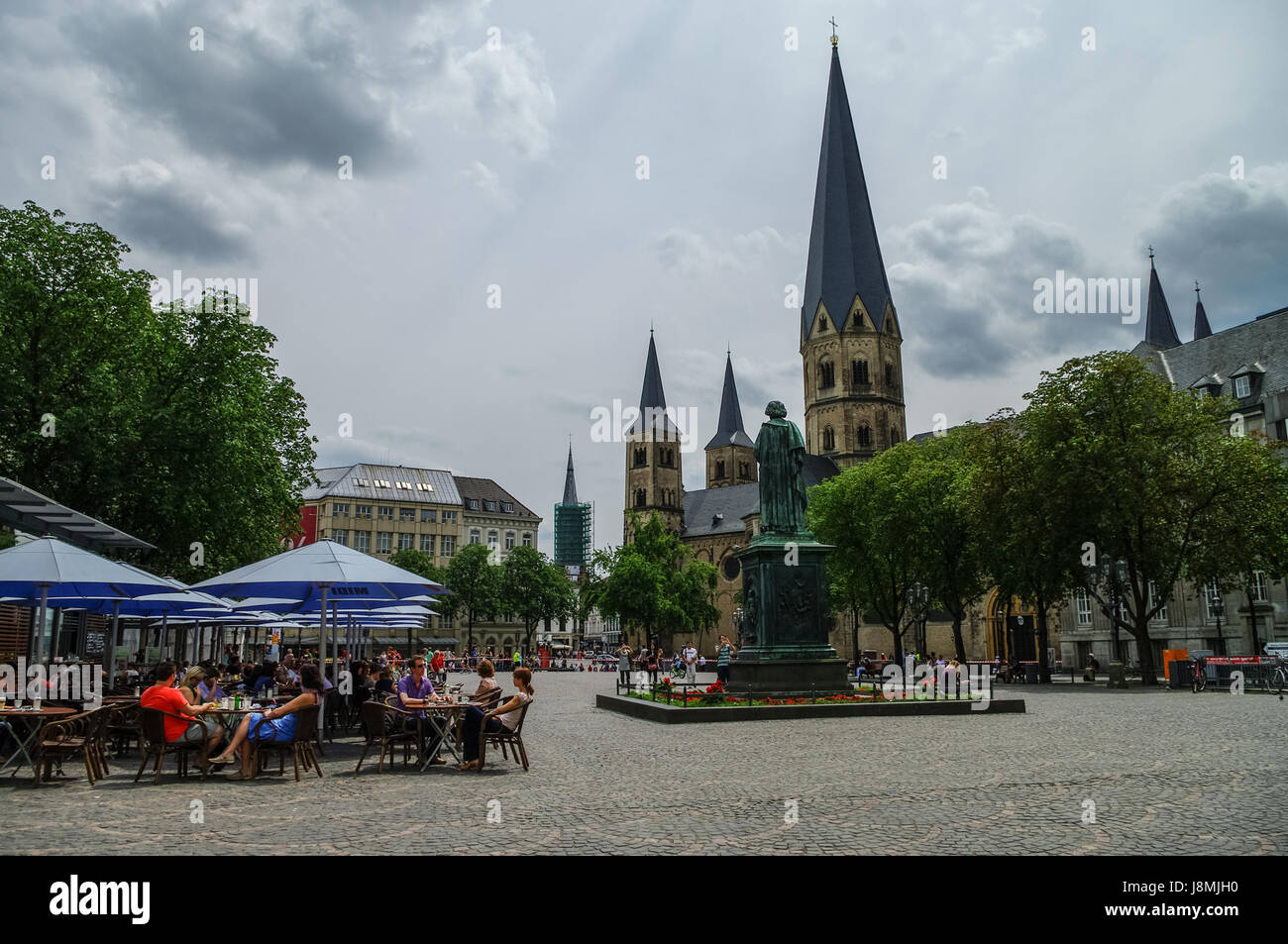 Bonn, Germany - July 10, 2011: Bonn market square with medieval church The Bonn Minster, statue of Beethoven and tourists in open cafe Stock Photo