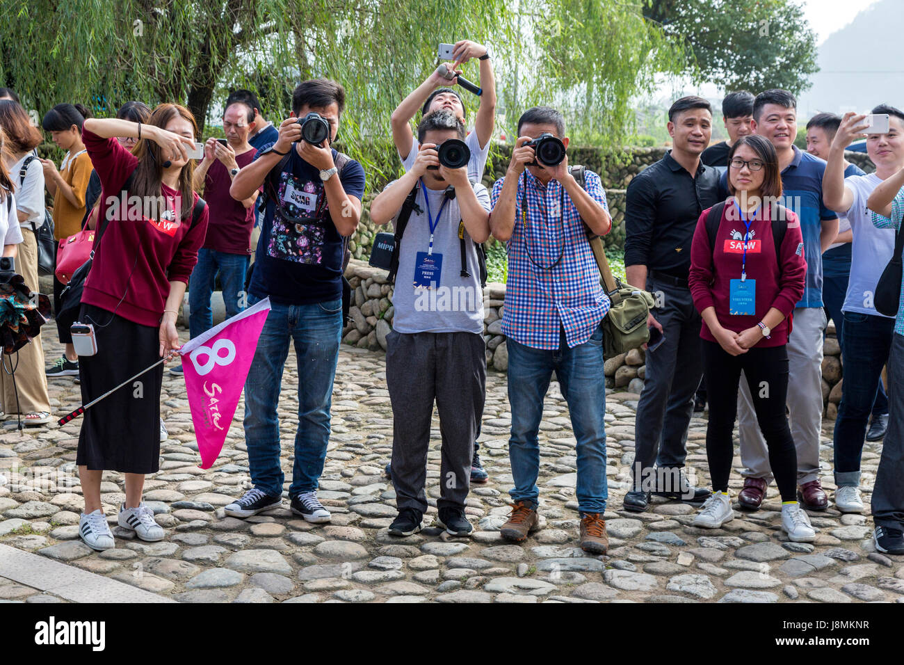 Cangpo, Zhejiang, China.  Chinese Journalists Photographing American Tourists Arriving at Village. Stock Photo