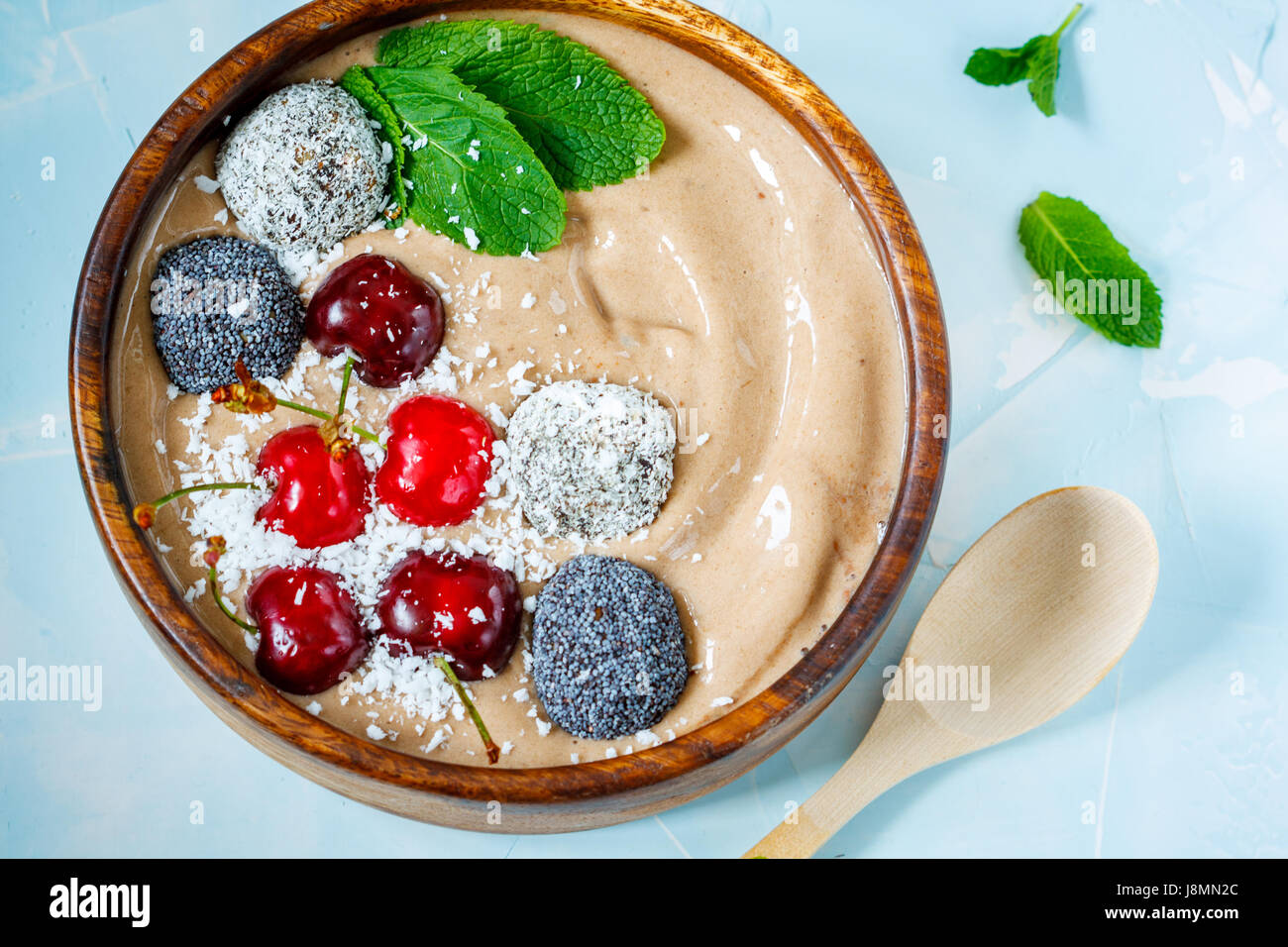 Chocolate smoothie bowl with cherry, mint and energy balls. Love for a healthy vegan food concept Stock Photo